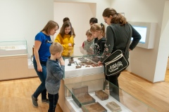 Kobieta opowiadająca i przeprowadzająca dzieci po muzeum
