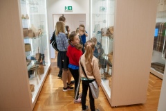 Kobieta opowiadająca i przeprowadzająca dzieci po muzeum