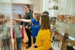 Kobieta opowiadająca i przeprowadzająca dzieci po muzeum