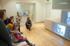 Kobieta opowiadająca i przeprowadzająca dzieci po muzeum