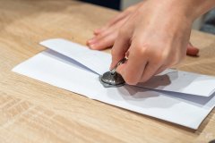 Dłoń odciskająca pieczęć w laku na liście