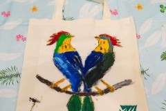Kolorowe ptaki namalowane na płóciennej torbie