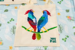 Kolorowe ptaki namalowane na płóciennej torbie