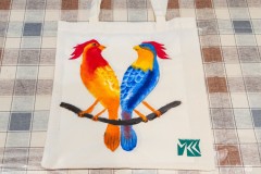 Kolorowe ptaki namalowane na płóciennej torbie