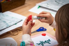 Dłonie dziecka sparujące mały element dekoracji klejem w sztyfcie