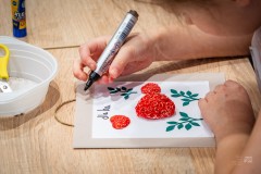 Dłonie dziecka piszące flamastrem na dekoracji w ramce