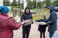 Uczestnicy rodzinnego pikniku edukacyjnego „Z małą walizką w dawny świat. Ułani od kuchni”. Otrzymują tekturowe walizki i materiały edukacyjne