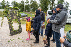 Uczestnicy pikniku na Fortach Bema stoją przed Wrotami Czasu oczekując na przejście. W tle pojazdy oraz krzyż