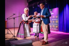 Na scenie mężczyzna i trzy kobiety wręczają nagrody twórczyniom