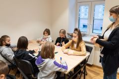 Uczestnicy warsztatów etnograficznych wykonują gwiazdki z bibuły