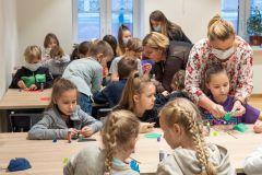 Uczestnicy warsztatów etnograficznych wykonują gwiazdki z bibuły