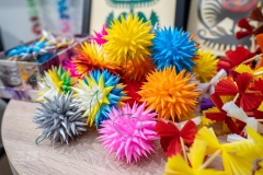 Na blacie leżą wielobarwne bombki na choinkę wykonane z papieru.