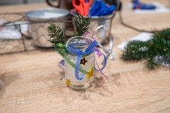 Udekorowany słoiczek przyklejone gałązki choinki, sznureczki i małe żółte gwiazdeczki