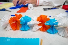 Na blacie leży łańcuch wykonany z bibuły, jest on trzy kolorowy.