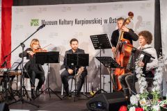 Muzyce na scenie. W tle ścianka z nazwą Muzeum i logotypami