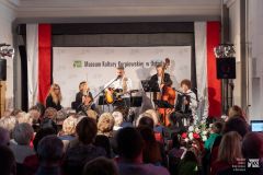 Na muzealnym dziedzińcu scena, na której występują muzycy. Przed sceną fragment publiczności