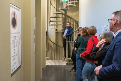 Siedem osób ogląda wystawę planszową