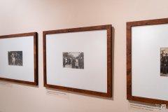 Trzy stare, czarnobiałe zdjęcia oprawione w ramki wiszą na ścianie.