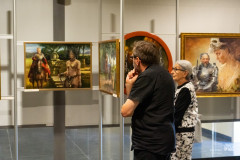 Kobieta i mężczyzna oglądają obrazy na wystawie