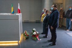 Delegacja złożyła kwiaty i stoi przed sarkofagiem w krypcie oddając hołd poległym.