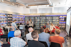 Uczestnicy edytonu zgromadzeni w bibliotece słuchają prelekcji