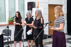 Cztery kobiety stoją przy mikrofonach