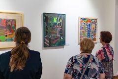 Ludzie oglądają obrazy na wystawie