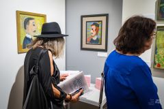 Ludzie oglądają obrazy na wystawie