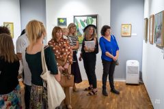 Ludzie oglądają obrazy na wystawie