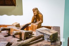 Fragment wystawy, na warsztacie wśród narzędzi stoi niewielka rzeźba przedstawiająca postać Chrystusa Frasobliwego