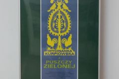 Plakat w ramie reklamujący wystawę.
