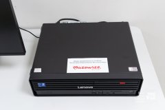 Komputer w obudowie poziomej na biurku. Komputer posiada naklejkę z logo marki Mazowsze